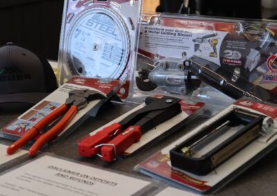 Display of various metalworking tools and a branded cap on a table.