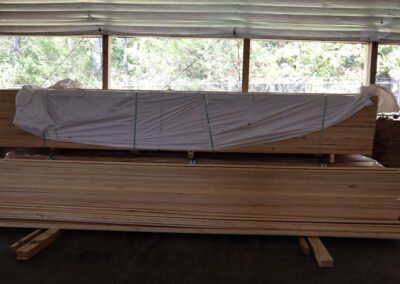 Stacks of treated lumber in a warehouse with labels indicating sizes.