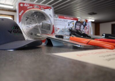 Workbench with a cap, saw blade packaging, and assorted tools in foreground.